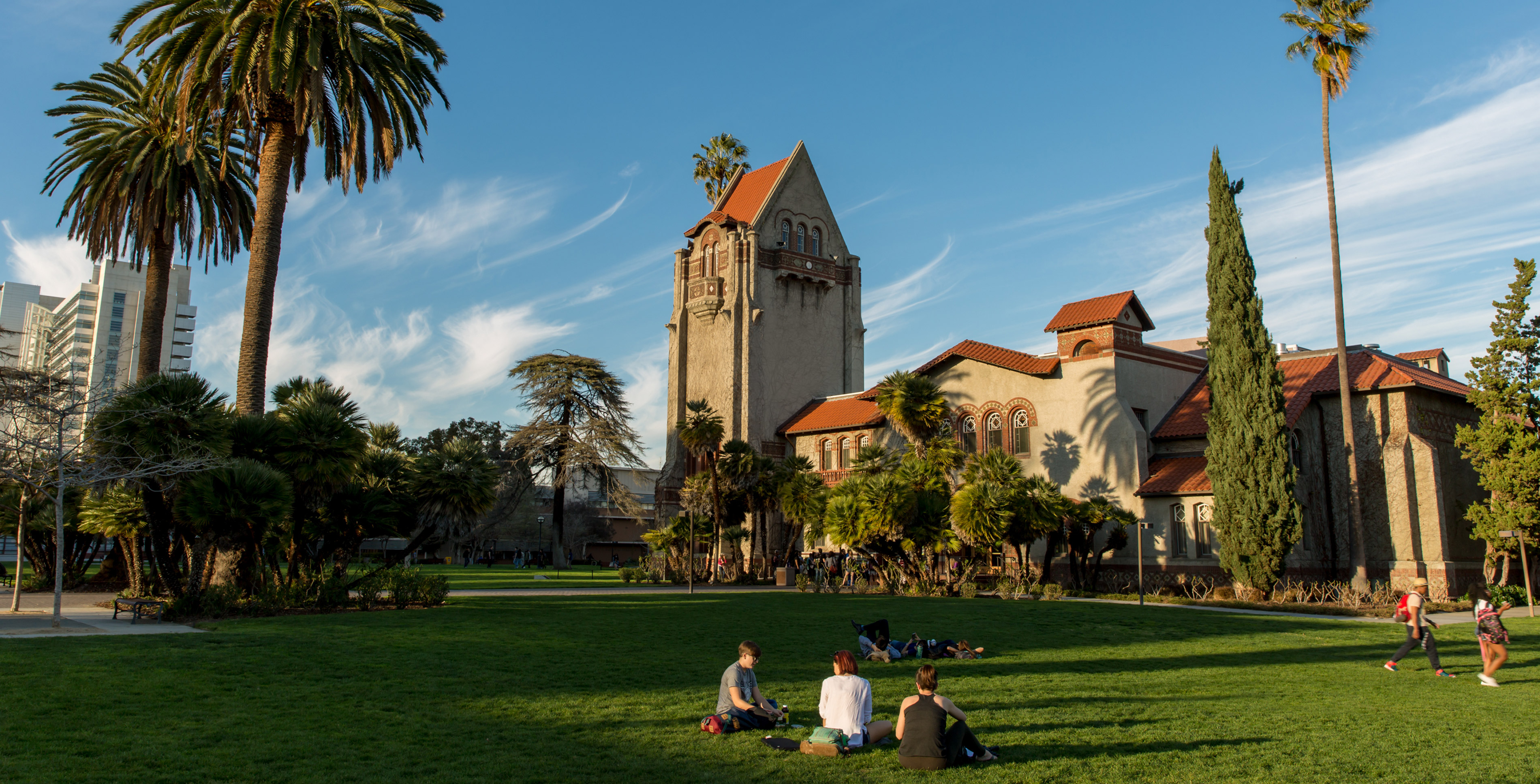 Students sitting on lawn in front of Tower Hall