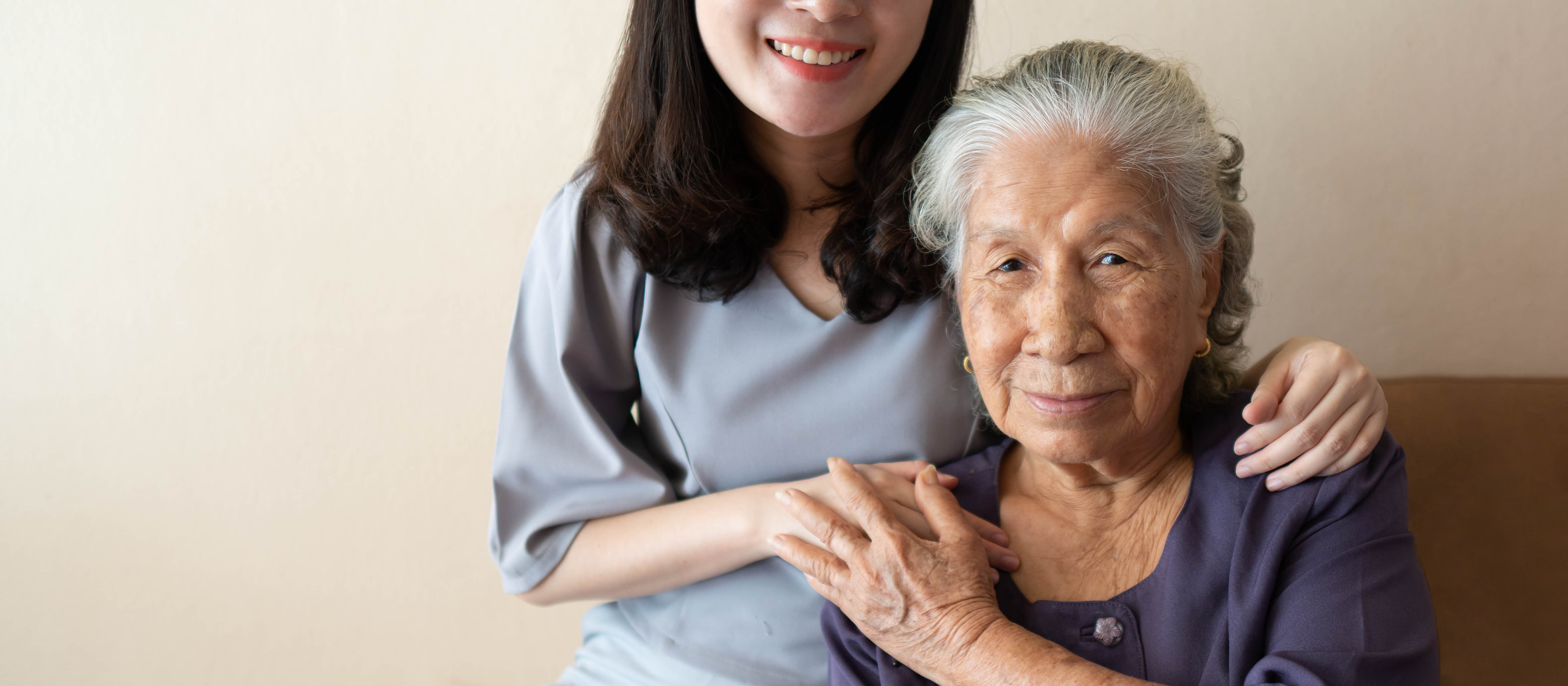 half concealed face caregiver holds onto an elderly woman