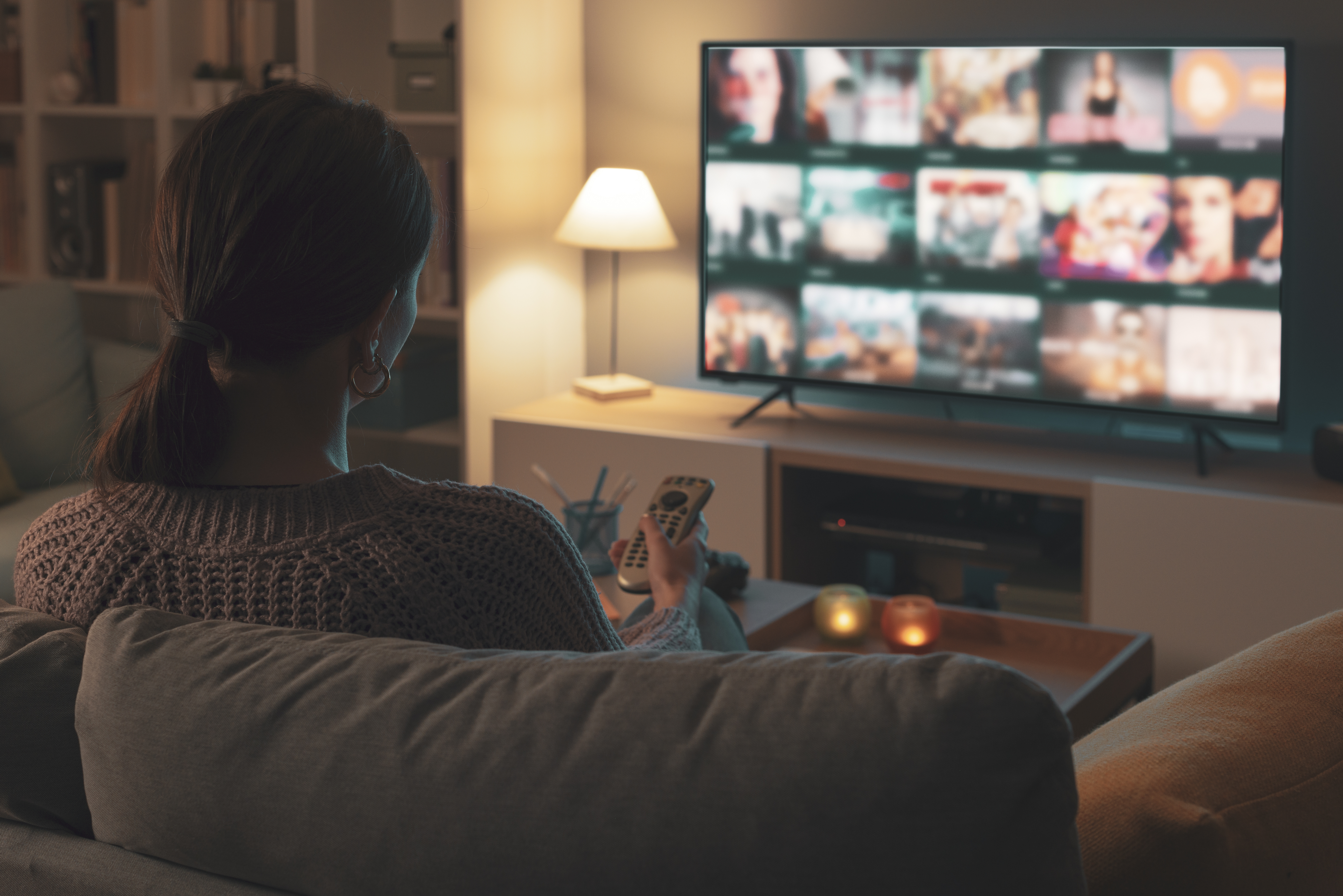 Woman picking movie through streaming app on TV